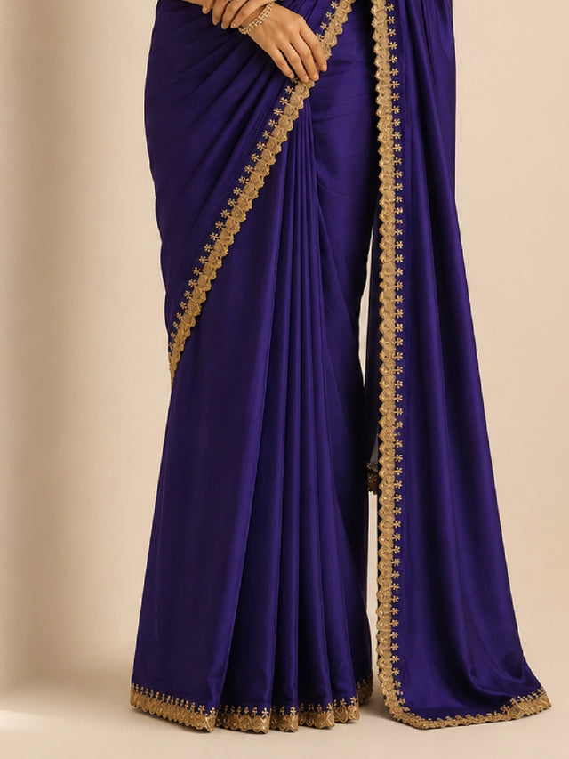 Woman in a purple saree with golden border and matching golden blouse.