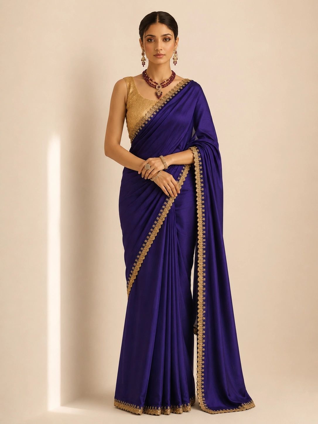 Woman in a purple saree with golden border and matching golden blouse.