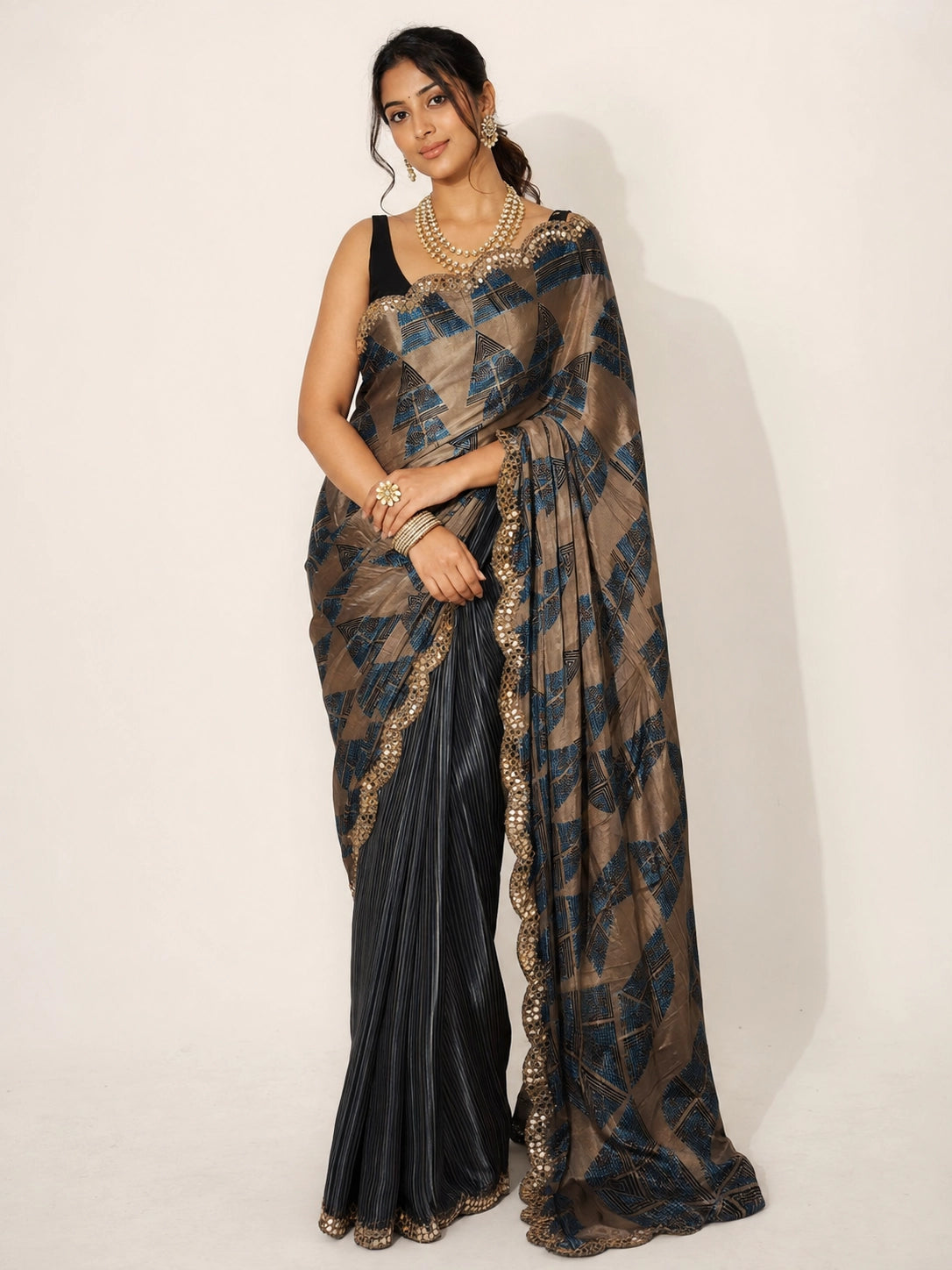 Woman in elegant grey and bronze  saree with geometric patterns and embellished border.