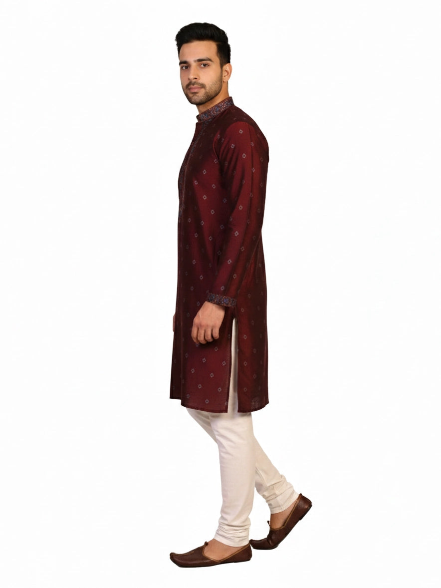 Man wearing a maroon kurta with a diamond pattern and embroidered neckline, paired with cream pants.
