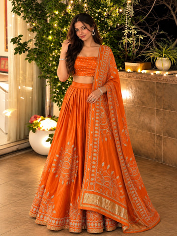 Woman in elegant rust embroidered lehenga choli set with matching dupatta.