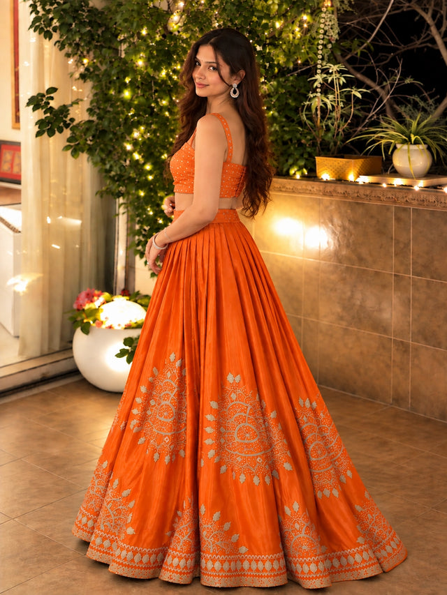 Woman in elegant rust embroidered lehenga choli set with matching dupatta.
