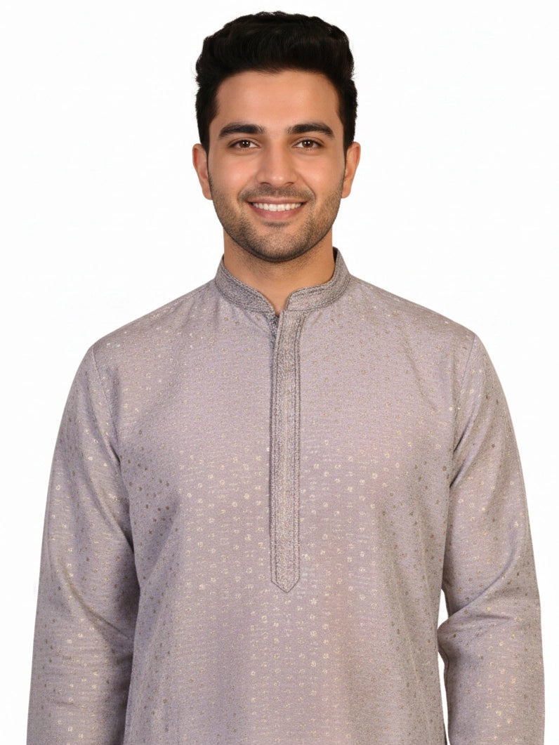 Man wearing a grey Kurta Pajama with a subtle geometric pattern and cream churidar pants.