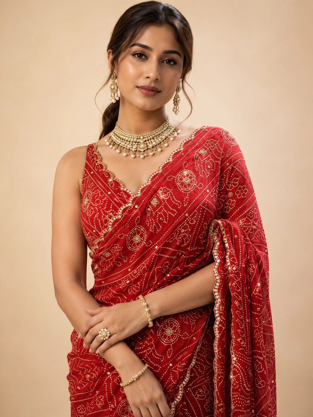 Woman in a vibrant red Bandhani saree with gold patterns and a matching blouse.