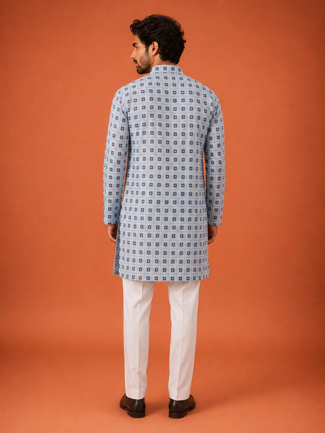 Man wearing sky blue geometric print kurta with white pajama and dark loafers.