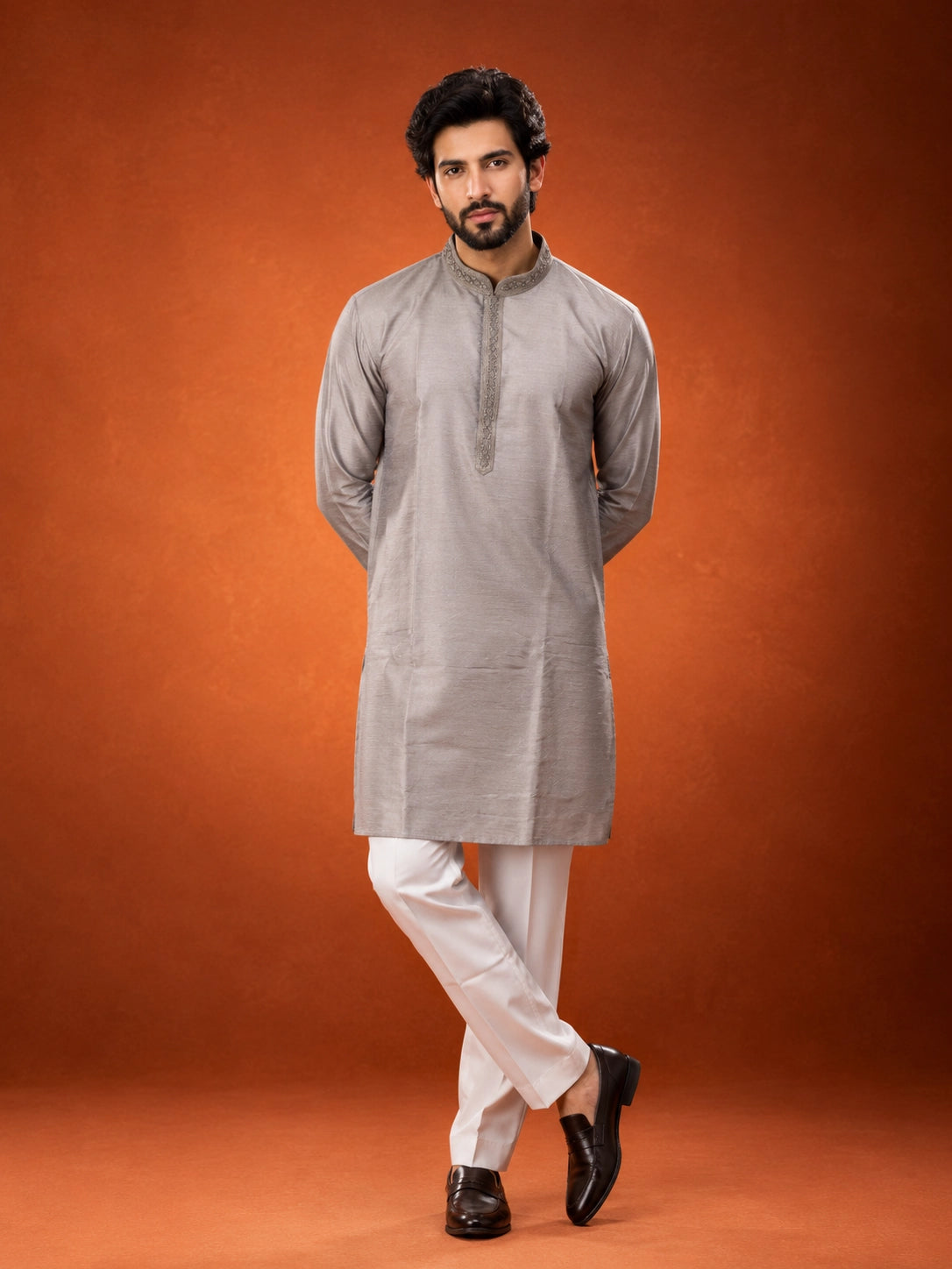 Man in elegant grey kurta with embroidered collar and white pajama set.