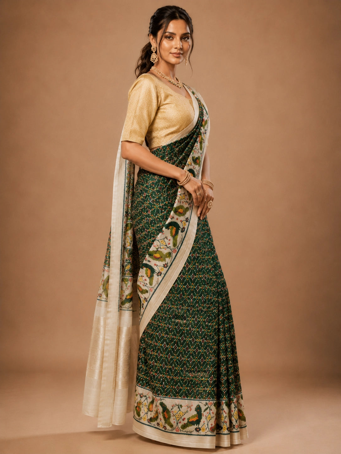 Woman in an elegant green Patola saree with a gold blouse and traditional jewelry.