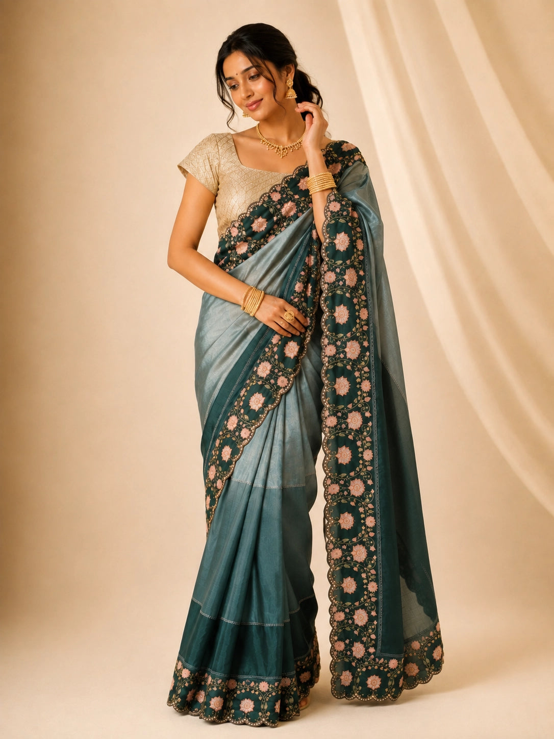 Woman wearing an elegant green embroidered saree with a golden blouse and traditional jewelry.