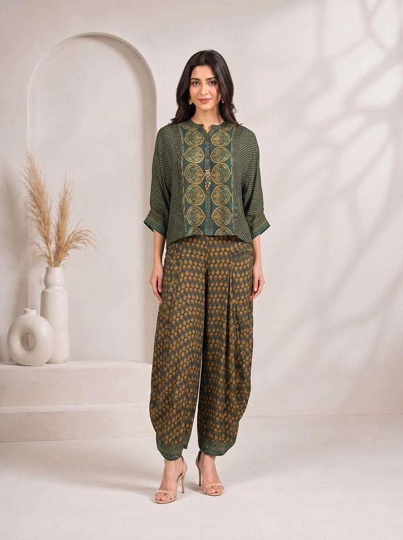Woman wearing a green printed kurta with flowing sleeves and matching dhoti pants, styled with nude heels.