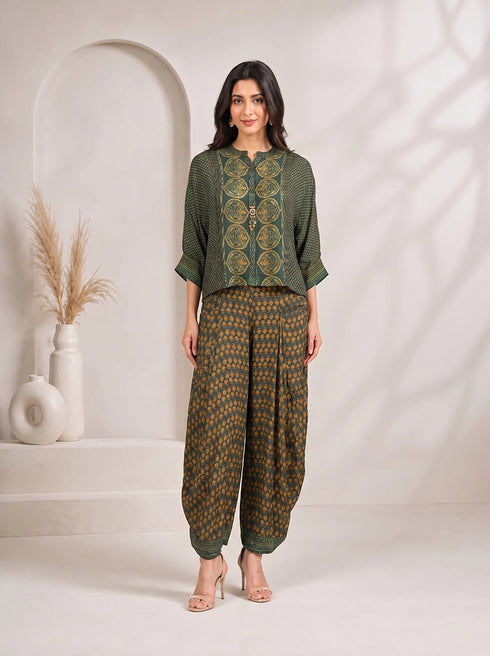 Woman wearing a green printed kurta with flowing sleeves and matching dhoti pants, styled with nude heels.