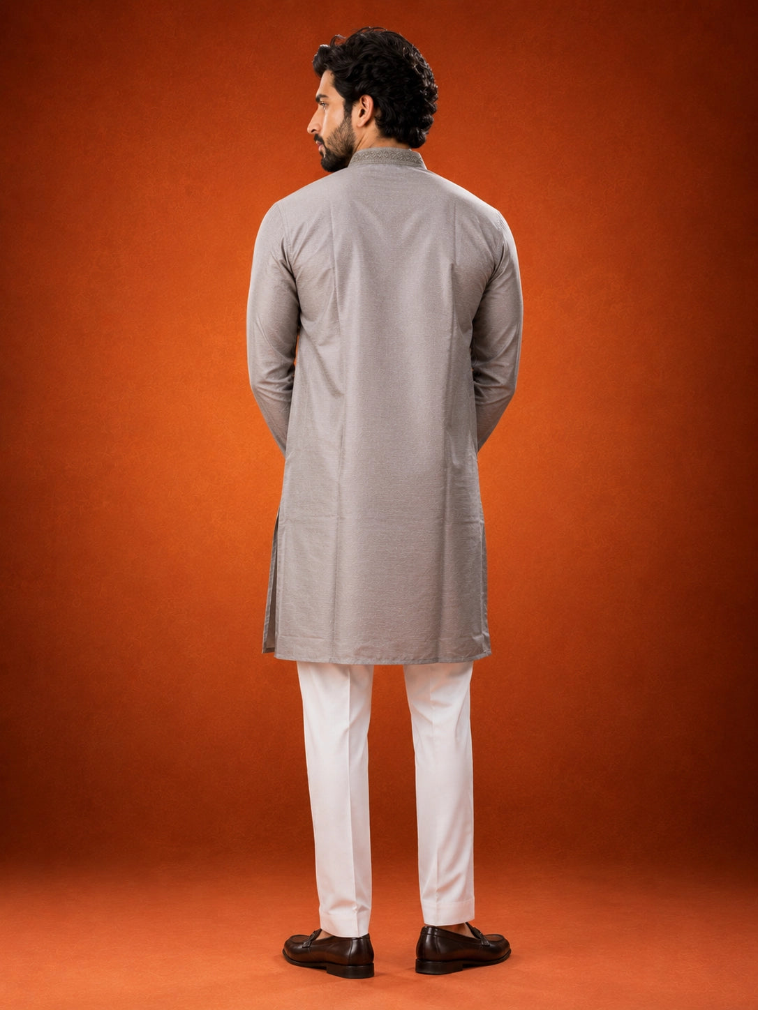 Man in elegant grey kurta with embroidered collar and white pajama set.