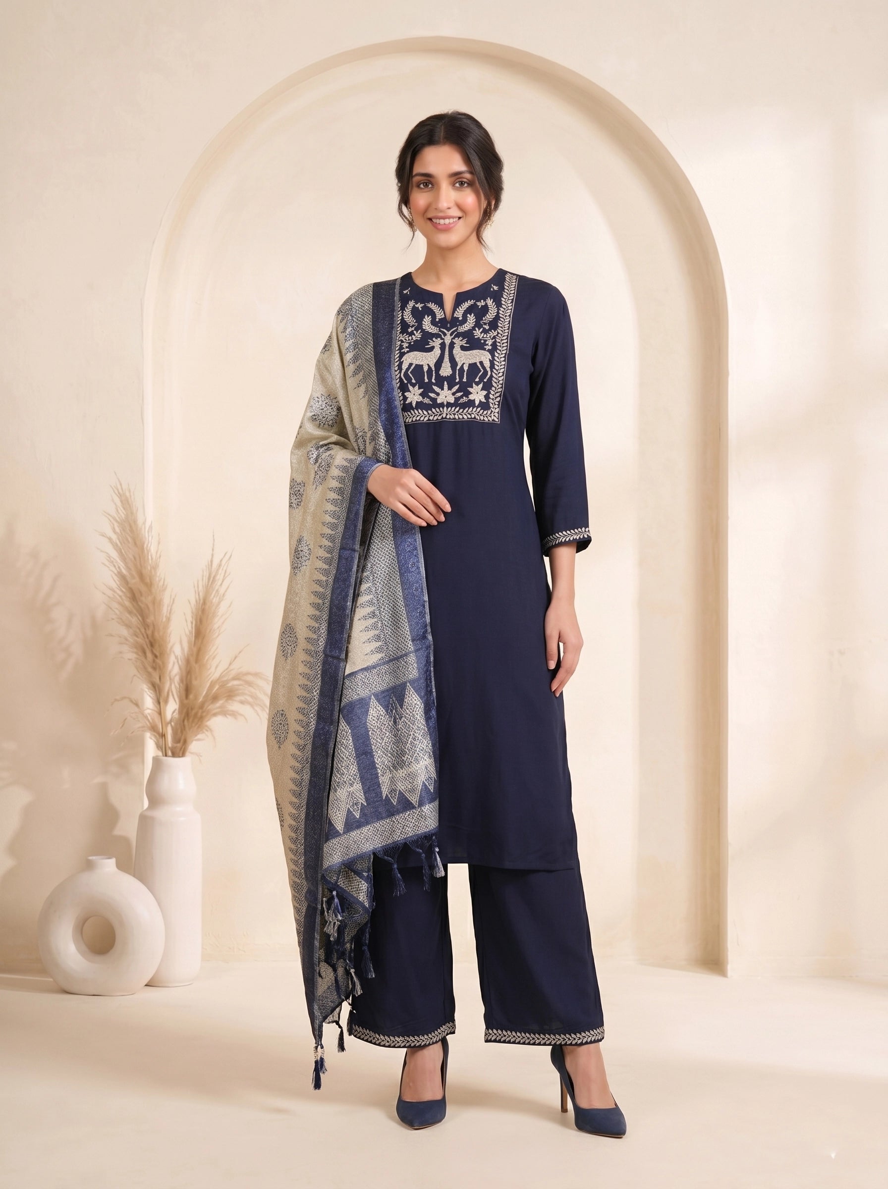 Navy blue embroidered kurti and pants set with a printed dupatta draped over the shoulder.