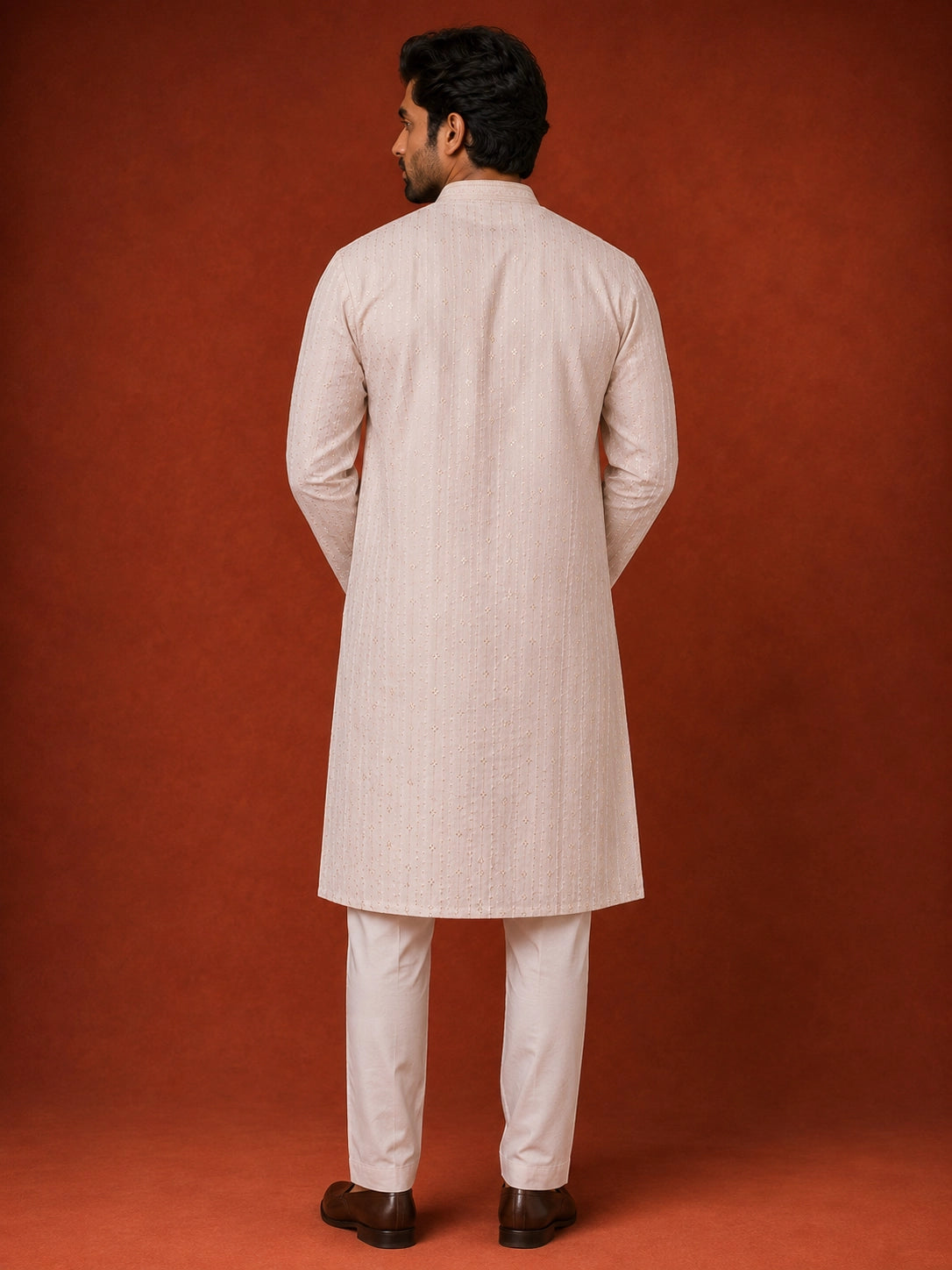 Man in elegant white kurta pajama with subtle vertical and diamond patterns.