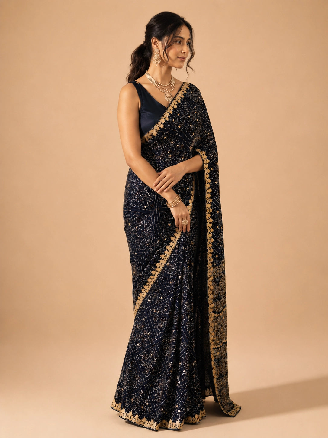 Woman in elegant navy blue  saree with gold embroidery and mirror work.
