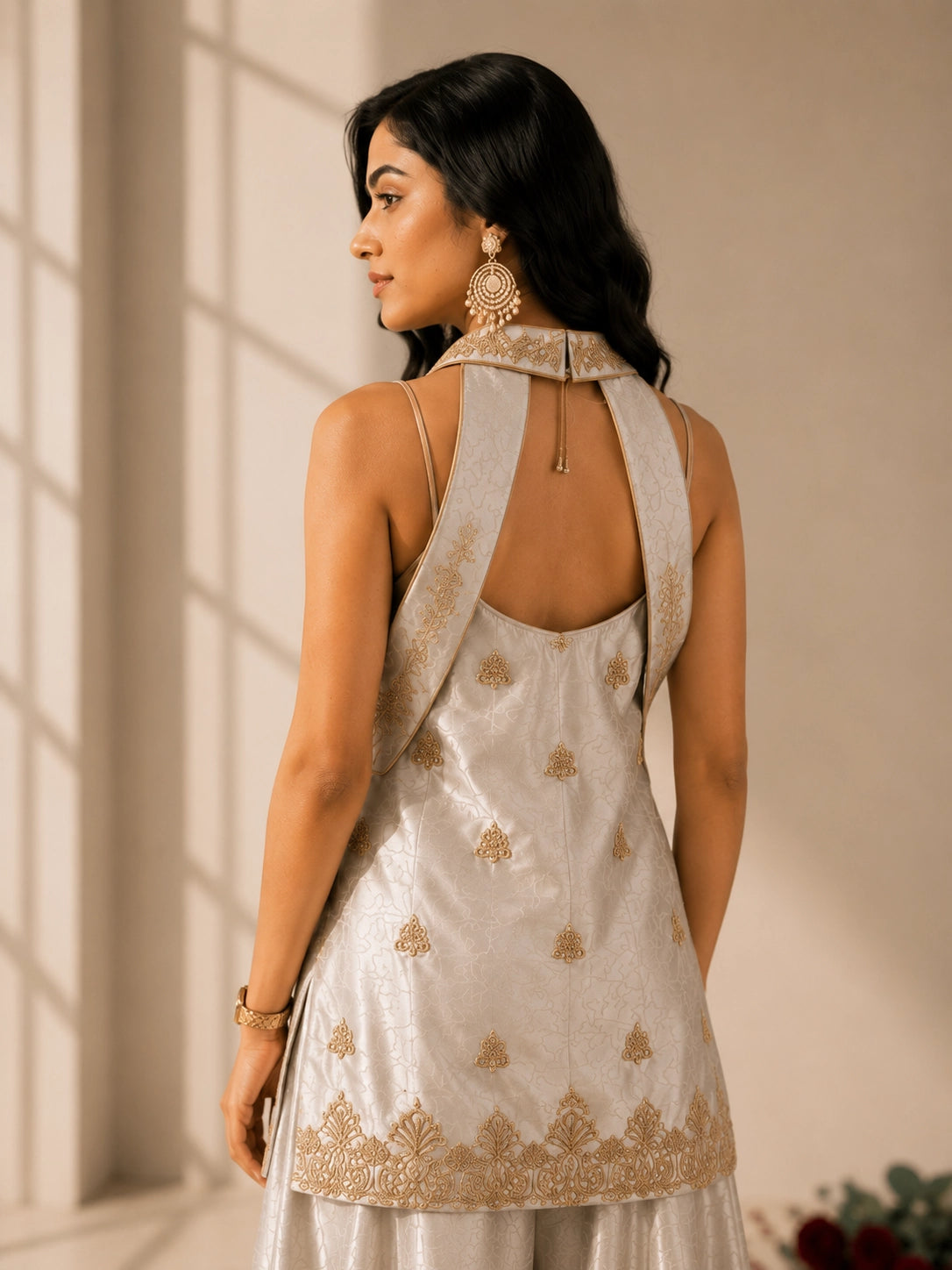 Woman in elegant grey sleeveless kurti with gold embroidery and matching palazzo pants.