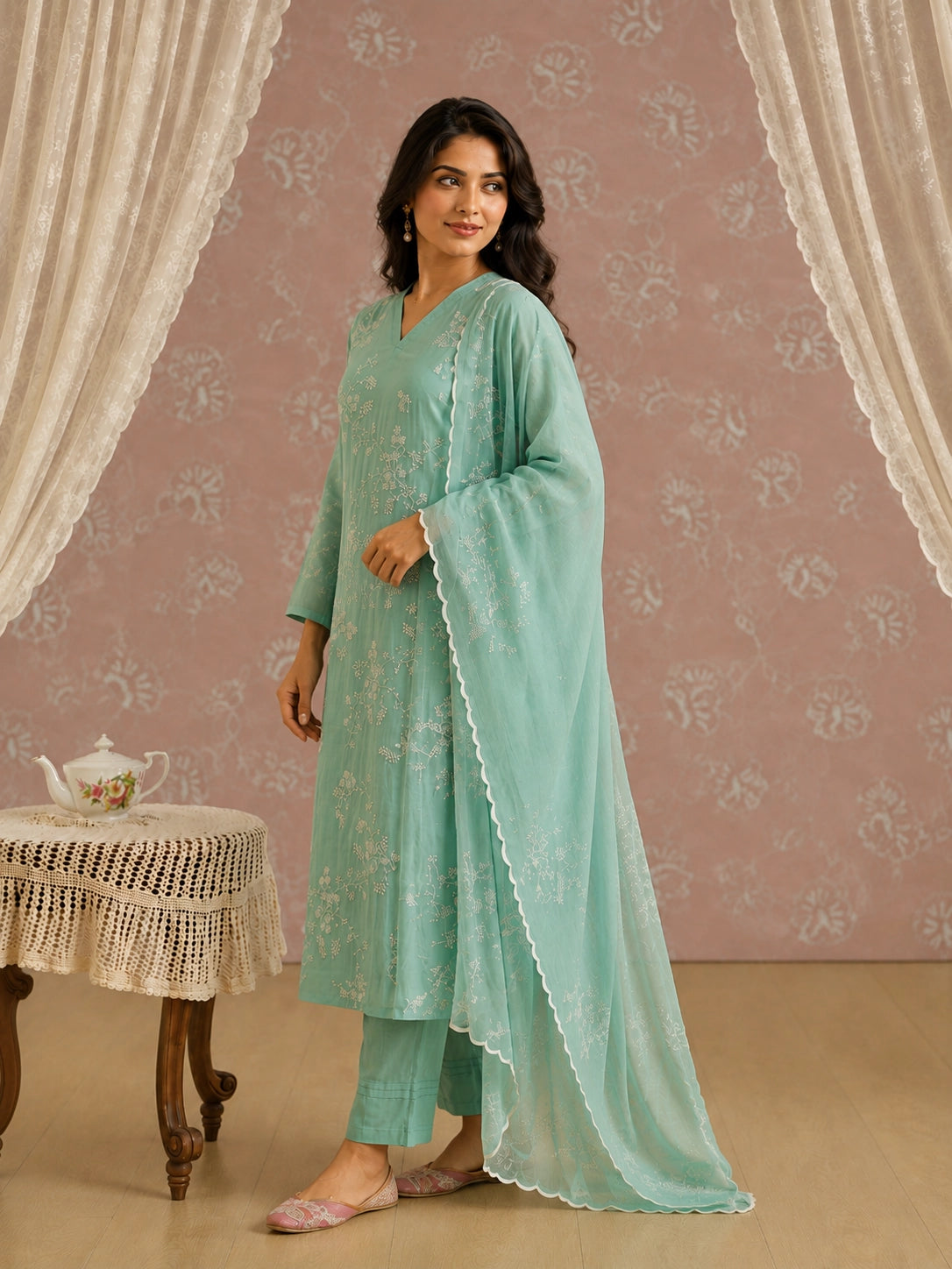 Woman wearing an elegant light green kurti with intricate white floral embroidery.