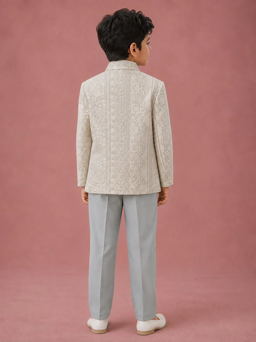 Young boy wearing a pista green Indo-Western suit with an intricately embroidered jacket.