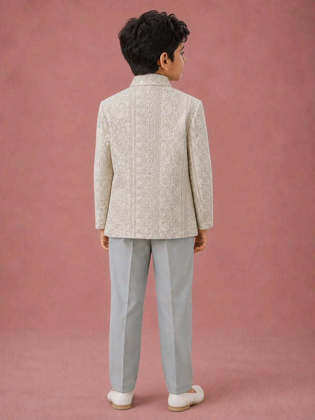 Young boy wearing a pista green Indo-Western suit with an intricately embroidered jacket.