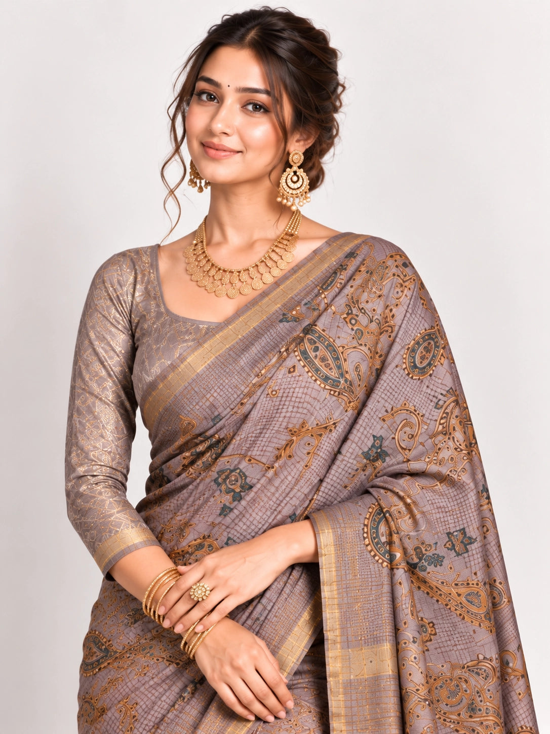 Woman in an elegant lavender grey saree with gold border and intricate paisley patterns.