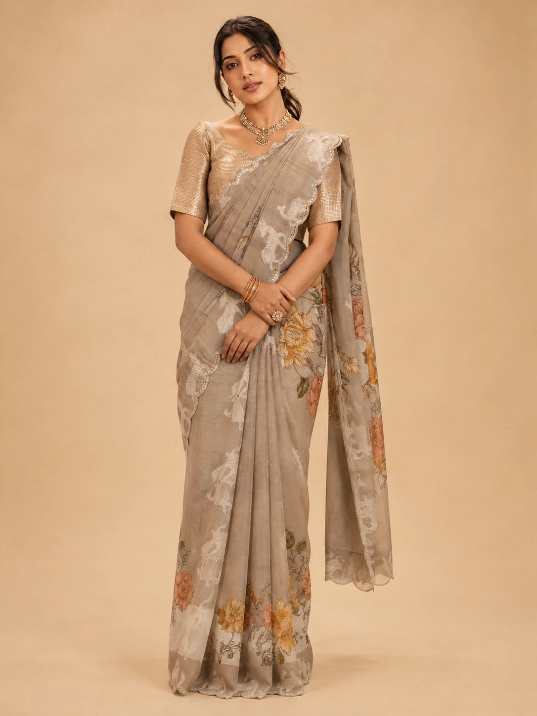 Woman wearing an elegant  peach floral saree with animal motifs and a golden blouse.