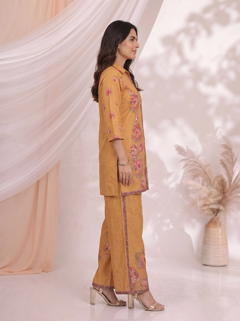 Woman wearing an ochre yellow kurta and palazzo set with a vibrant floral print.