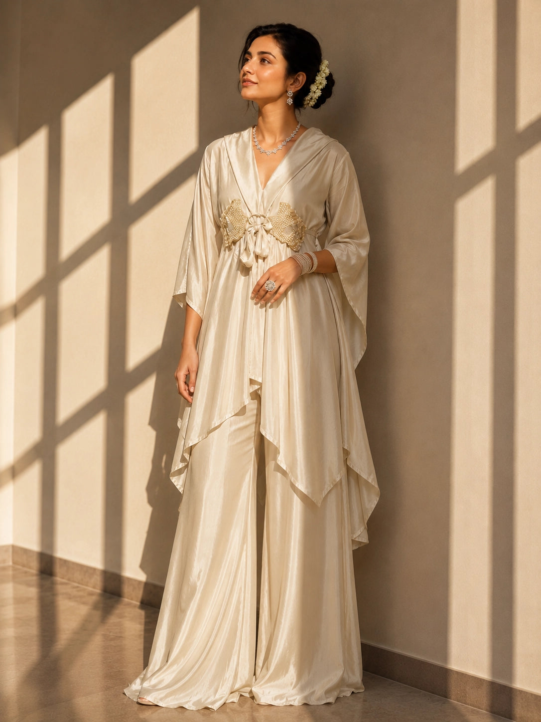 Woman in elegant beige kaftan-style kurti with embellished waist and wide-leg palazzo pants.