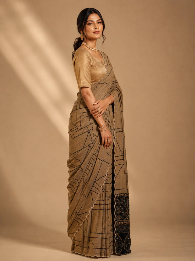 Woman in elegant brown  saree with black geometric print and embellished border.