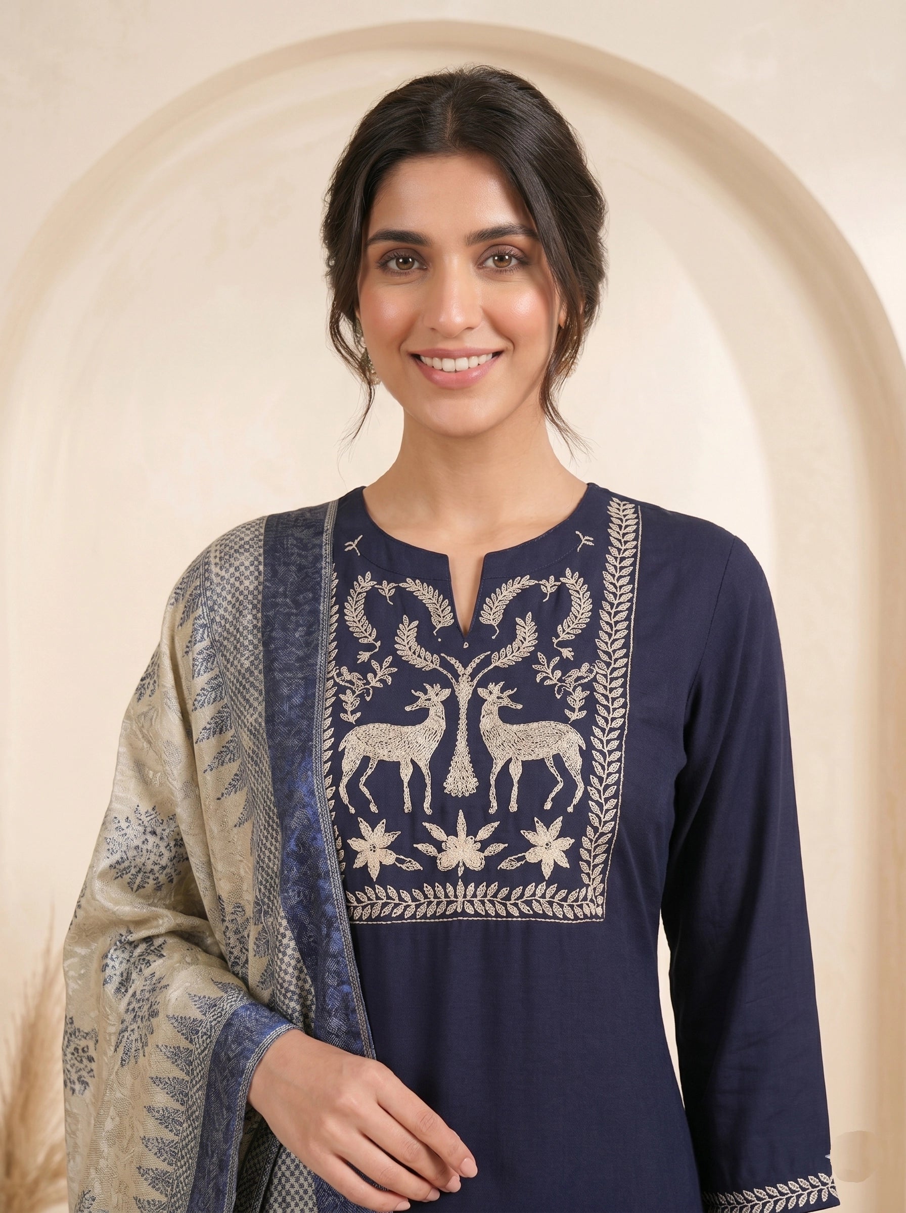 Navy blue embroidered kurti and pants set with a printed dupatta draped over the shoulder.
