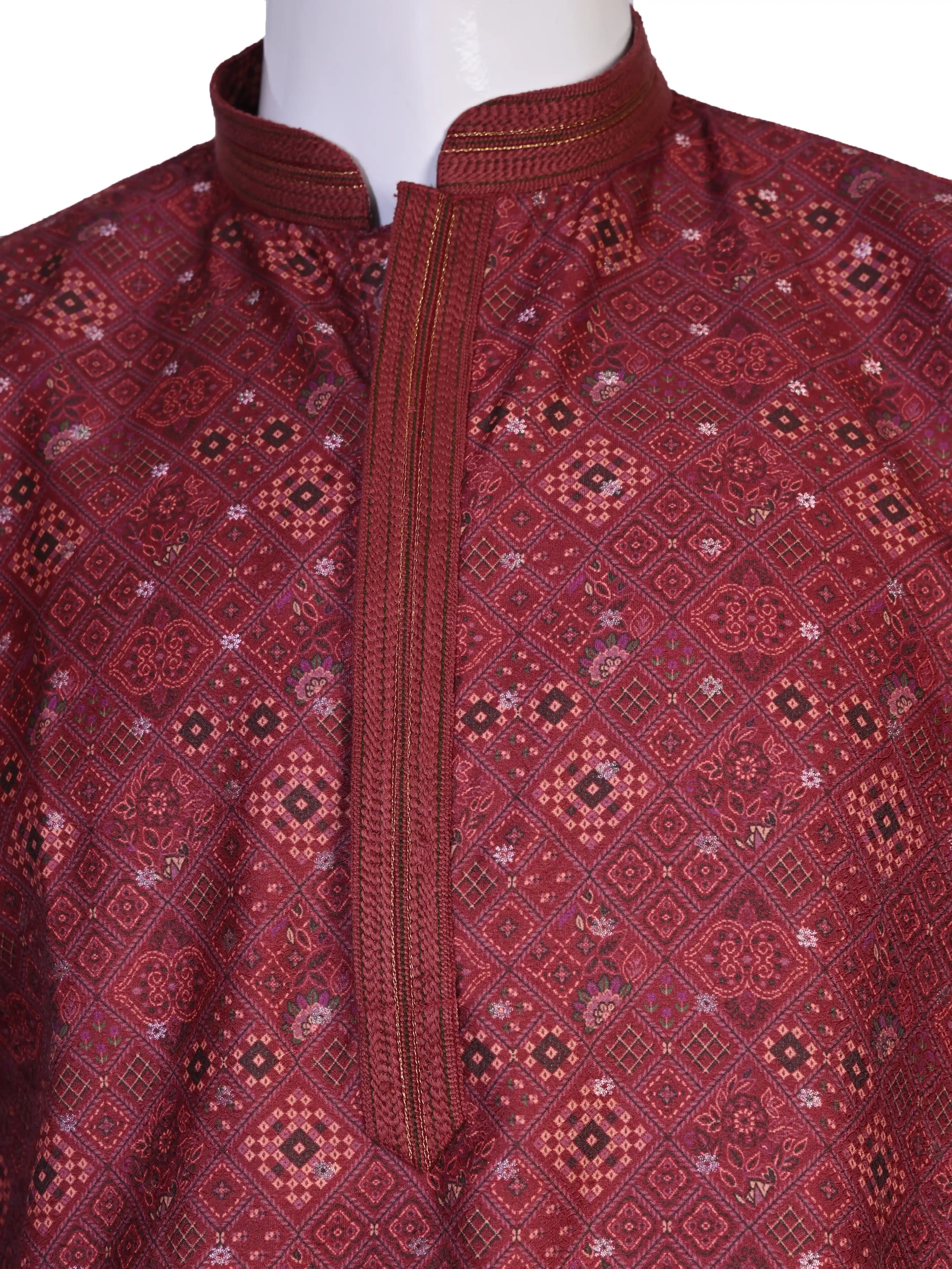 Man wearing a maroon printed kurta with white pants and brown shoes, showcasing traditional Indian attire.