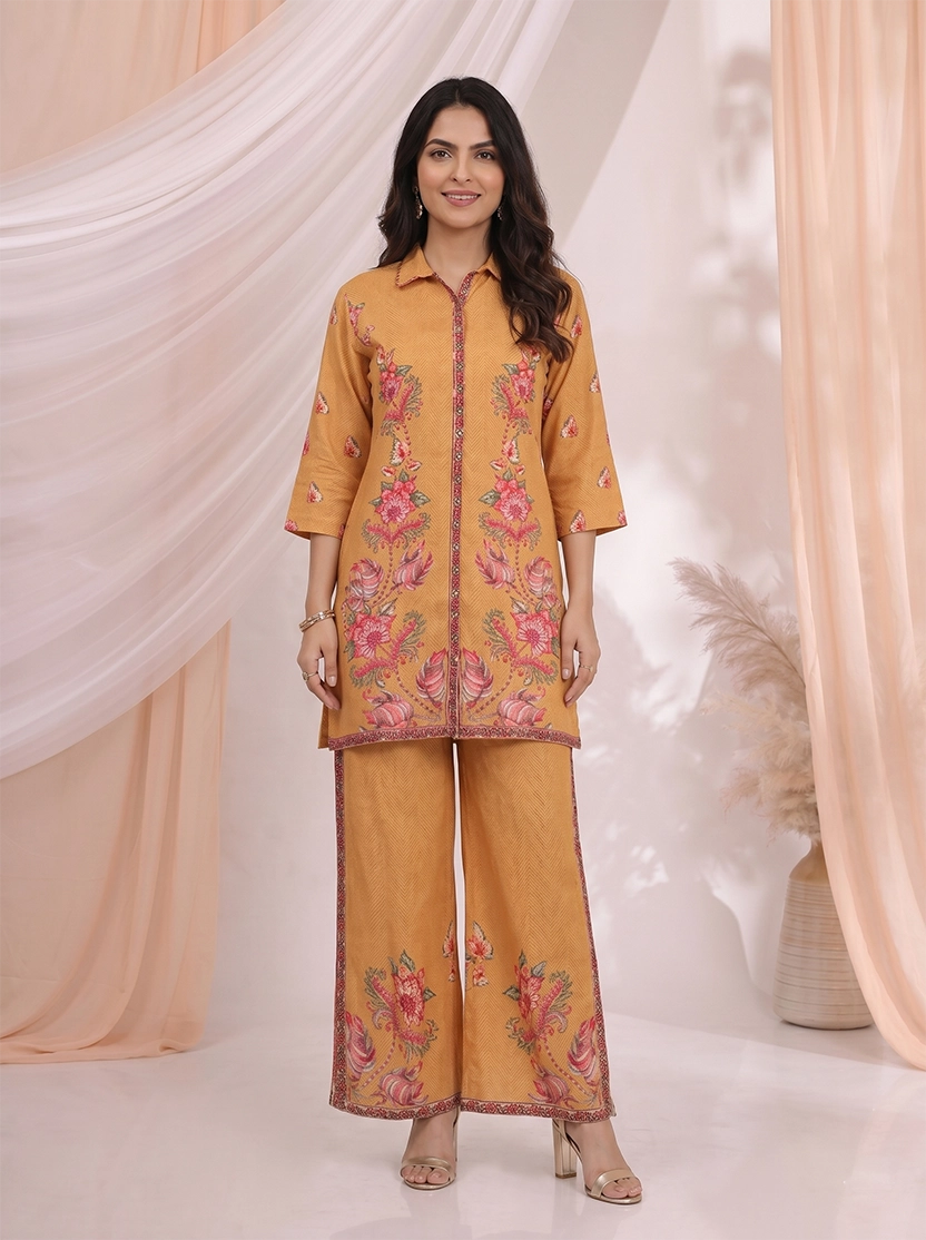 Woman wearing an ochre yellow kurta and palazzo set with a vibrant floral print.