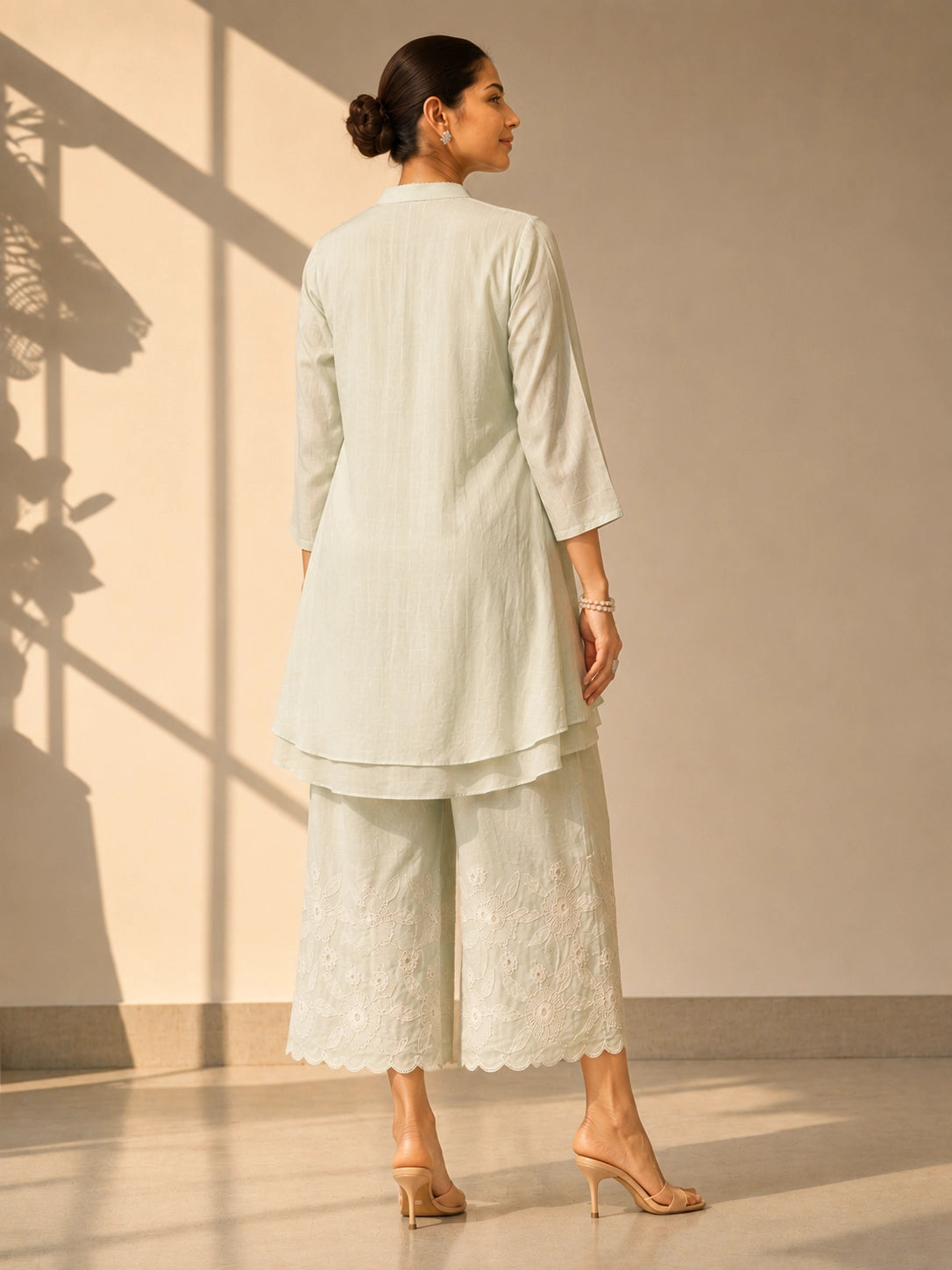 Woman in an elegant pista green embroidered tunic and wide-leg palazzo set.