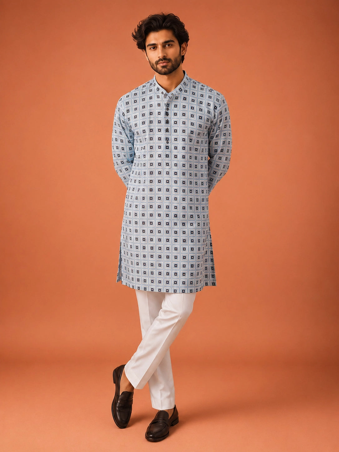 Man wearing sky blue geometric print kurta with white pajama and dark loafers.