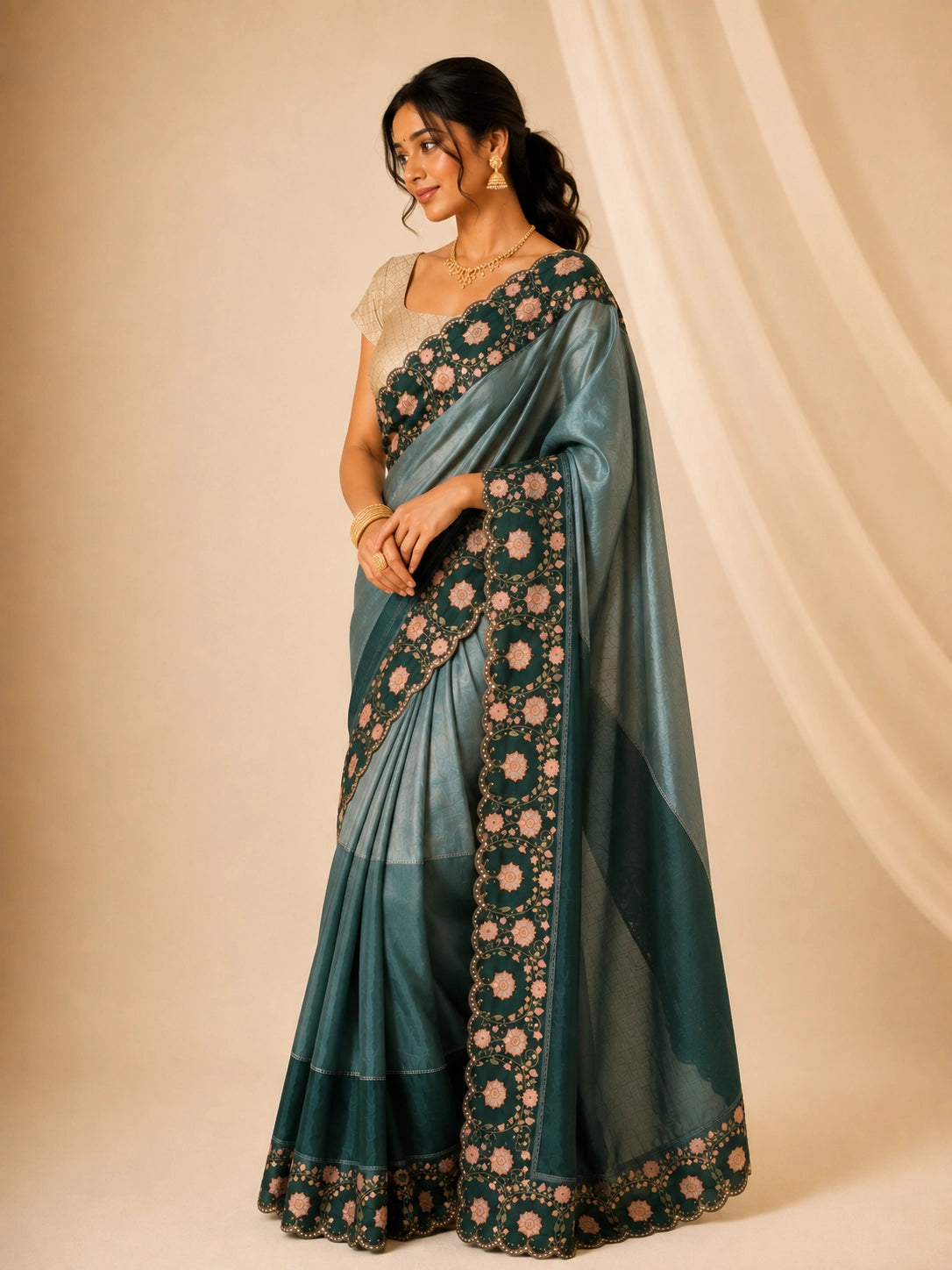 Woman wearing an elegant green embroidered saree with a golden blouse and traditional jewelry.