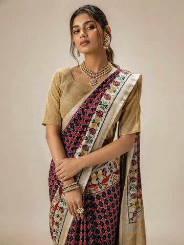 Woman wearing a purple ikat saree with a golden blouse and traditional jewelry.