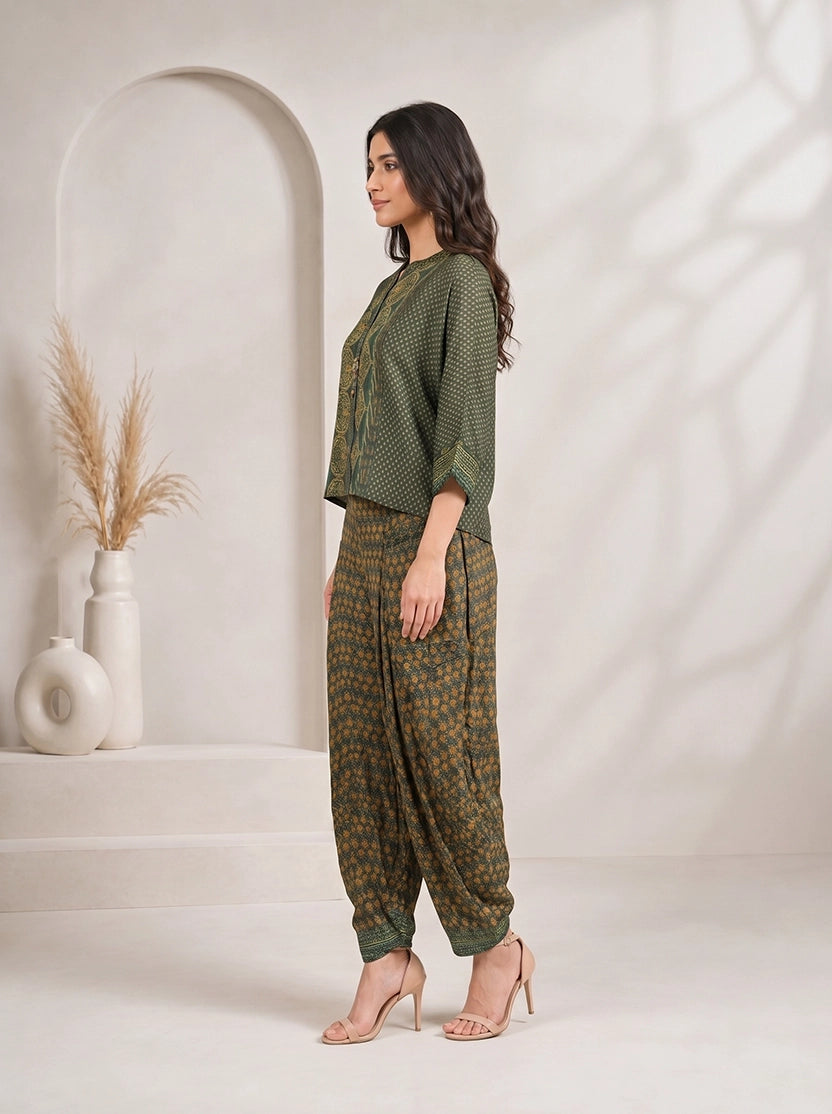 Woman wearing a green printed kurta with flowing sleeves and matching dhoti pants, styled with nude heels.