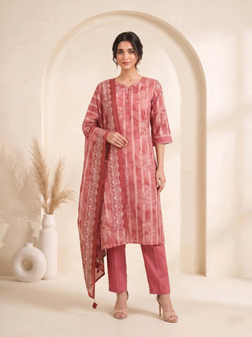 Woman wearing a rose pink printed kurti set with a dupatta, featuring leaf motifs and striped patterns.