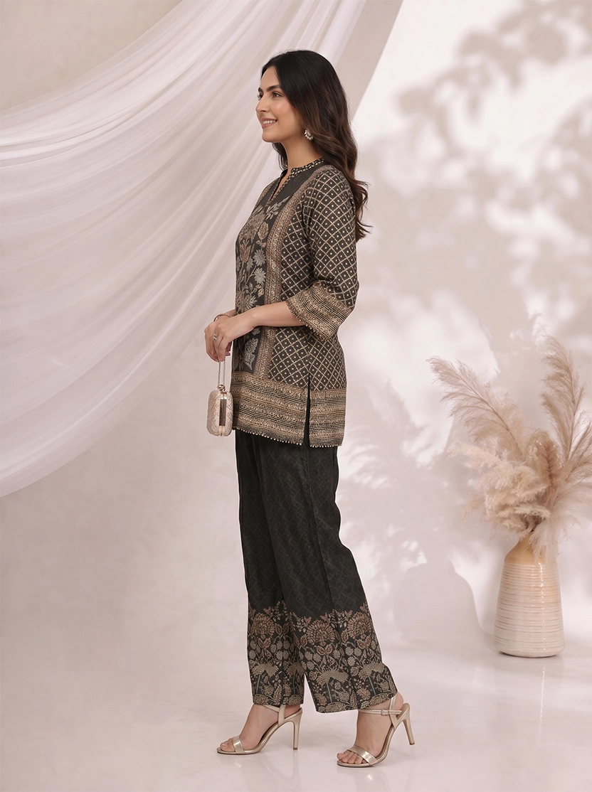 Woman wearing a black printed kurta with wide-leg pants, featuring floral motifs and a contrasting border.