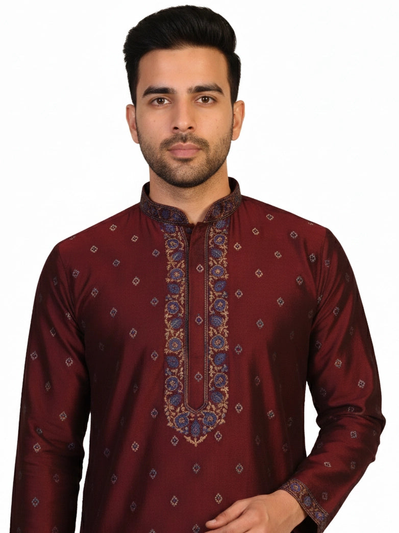 Man wearing a maroon kurta with a diamond pattern and embroidered neckline, paired with cream pants.