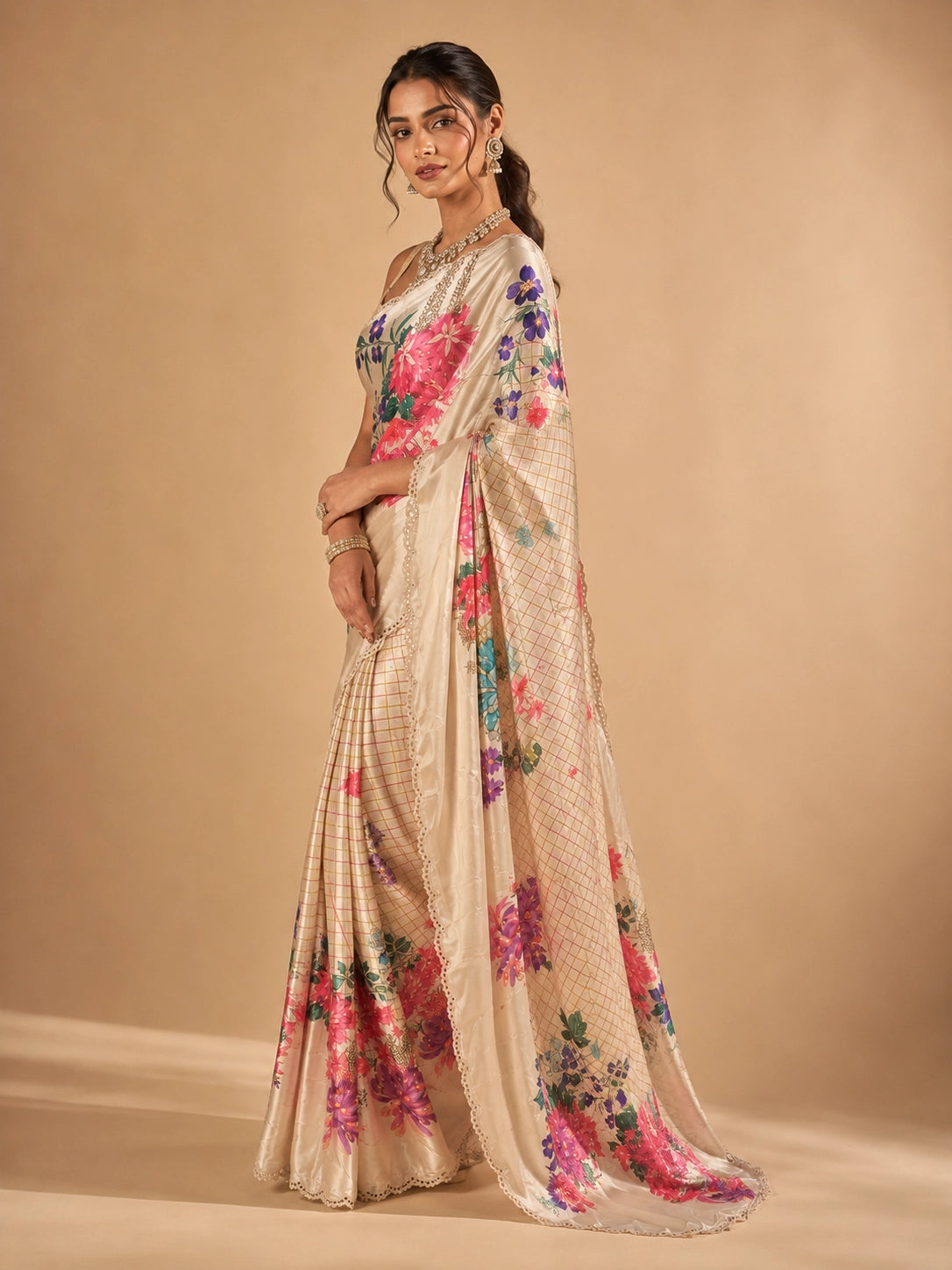 Woman in elegant cream floral saree with vibrant pink and purple flowers