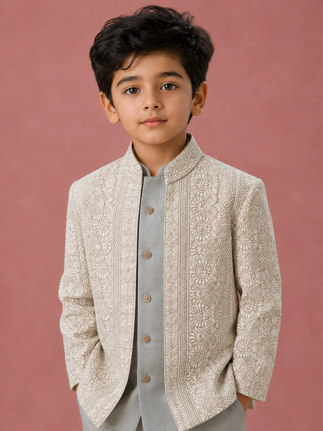 Young boy wearing a pista green Indo-Western suit with an intricately embroidered jacket.